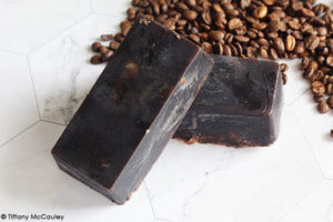 Two finished Pumpkin Spice Latte Soap sit near some coffee beans.